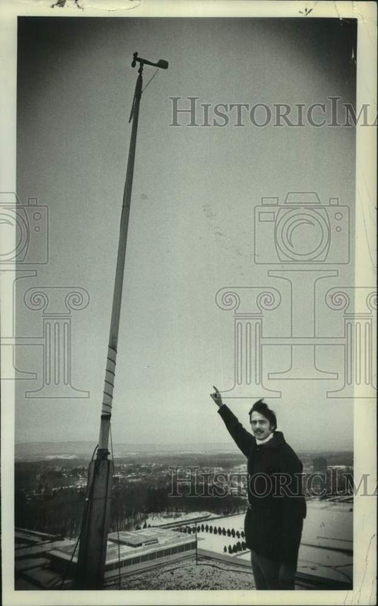 1977 Press Photo Bruce Bailey with weather gear on roof in Albany, New York - Historic Images