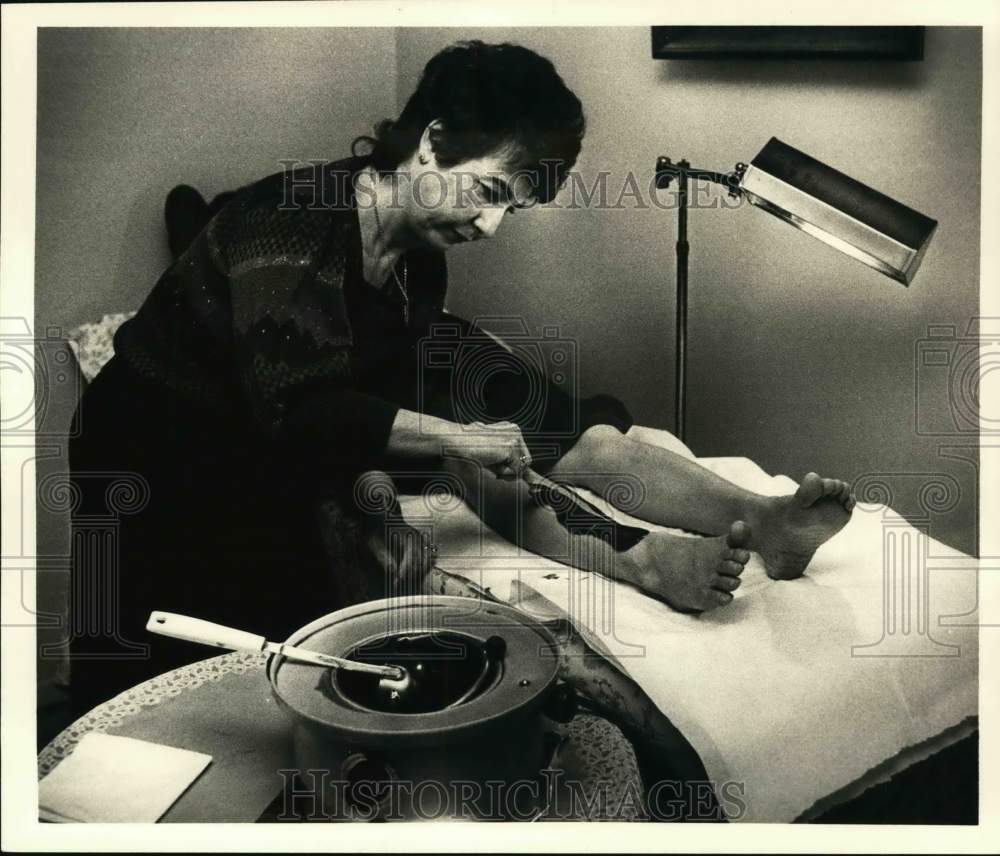 1986 Press Photo Teresa Avellino applies wax to leg of customer in New York - Historic Images