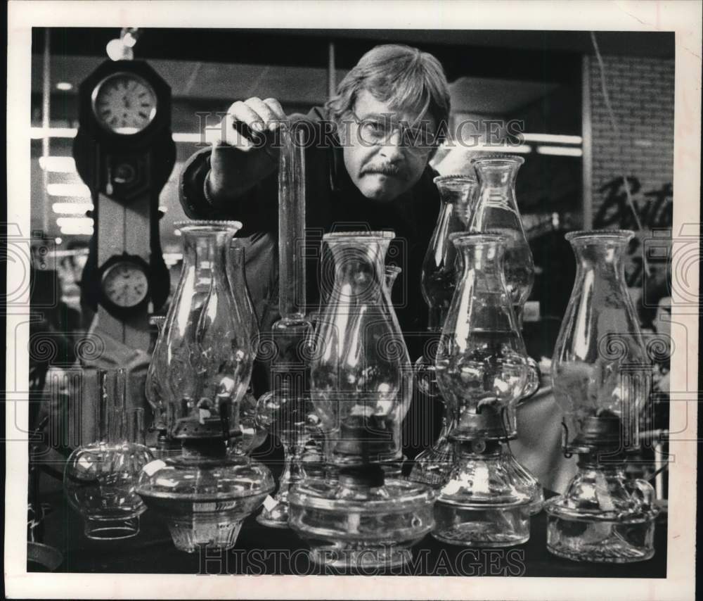 1980 Press Photo Robert Berroyer inspects antique glass lamps in New York - Historic Images