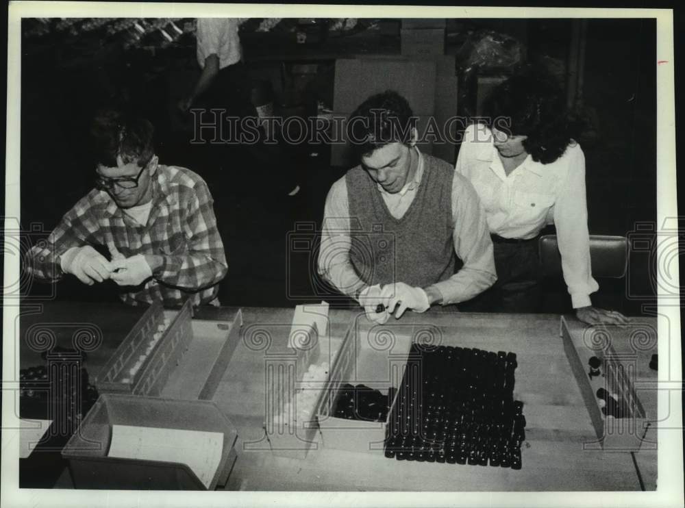 1989 Press Photo Supervisor watches over staff at New York production facility - Historic Images