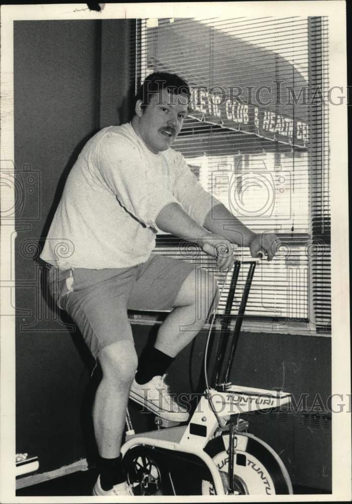 Press Photo Gerard Bray on exercise bike at New York athletic club - tua63728- Historic Images