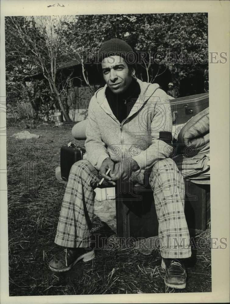 1976 Press Photo Hector Rivera smokes cigarette on New York park bench - Historic Images