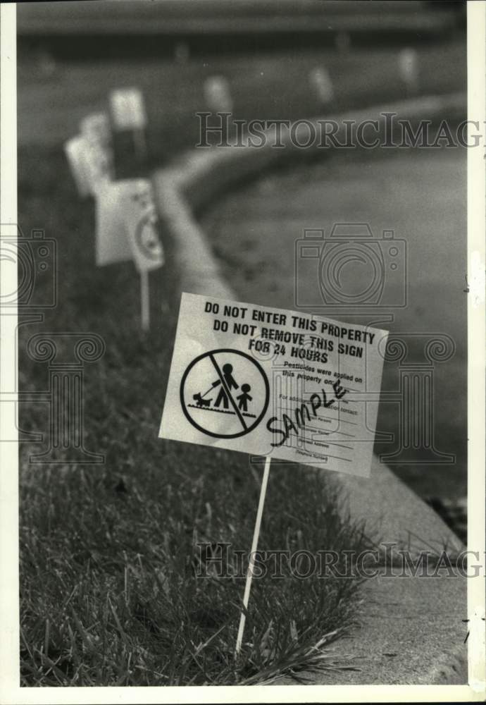 1987 Press Photo Pesticide signs on lawn of town library in Colonie, New York - Historic Images