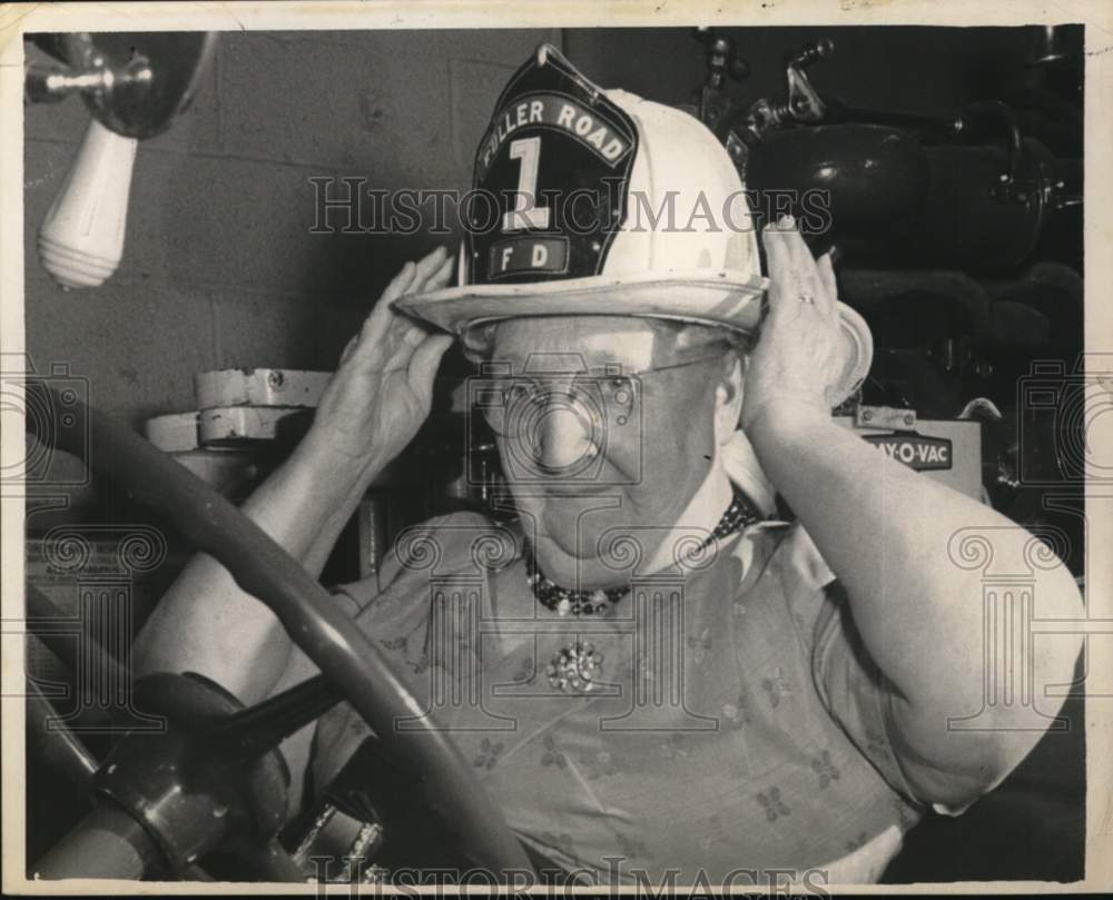 1962 Press Photo Mrs. William Bowles tries on firefighters hat in New York - Historic Images