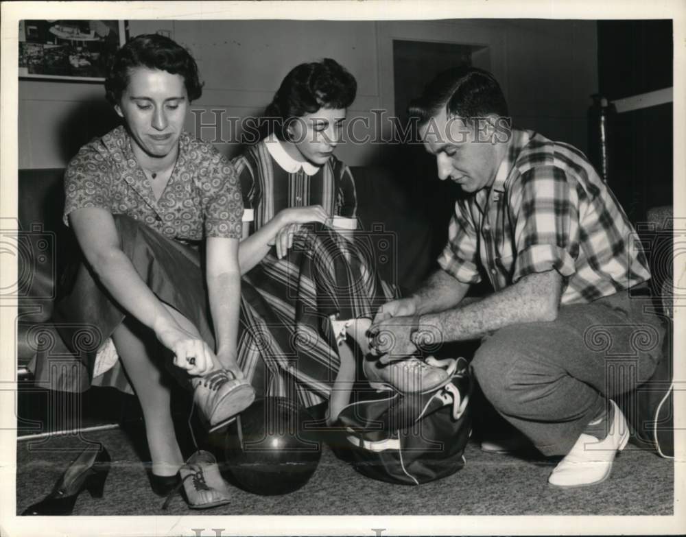 1958 Press Photo Group tying on bowling shoes in New York - tua78981- Historic Images