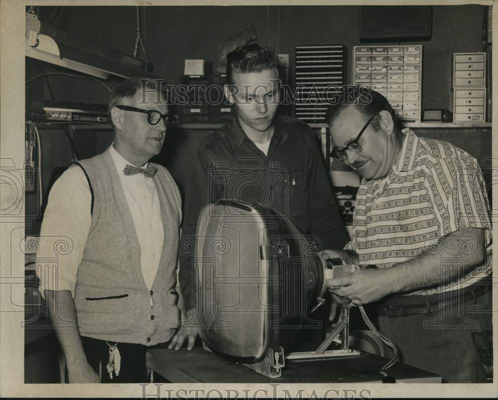 1960 Staff watches service manager repair television in New York-Historic Images