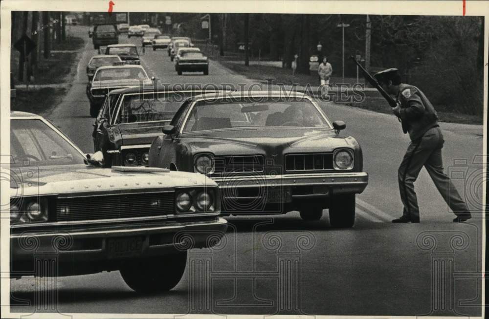 1975 Press Photo Colonie, New York police officer stops cars at road block - Historic Images