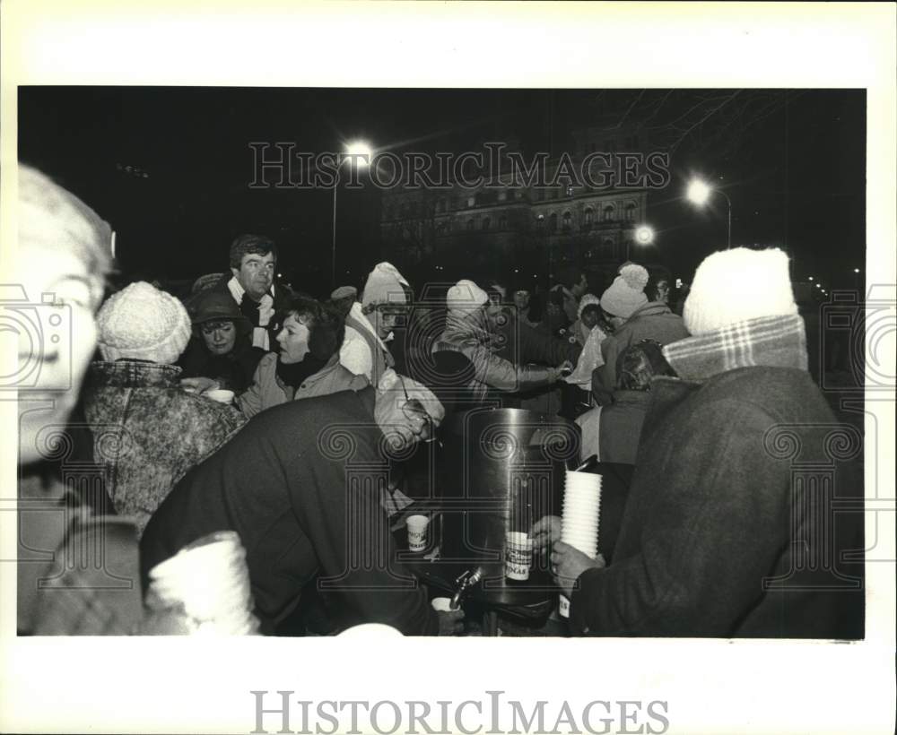 Press Photo Group gathers for eggnog at at First Night event, Albany, New York - Historic Images