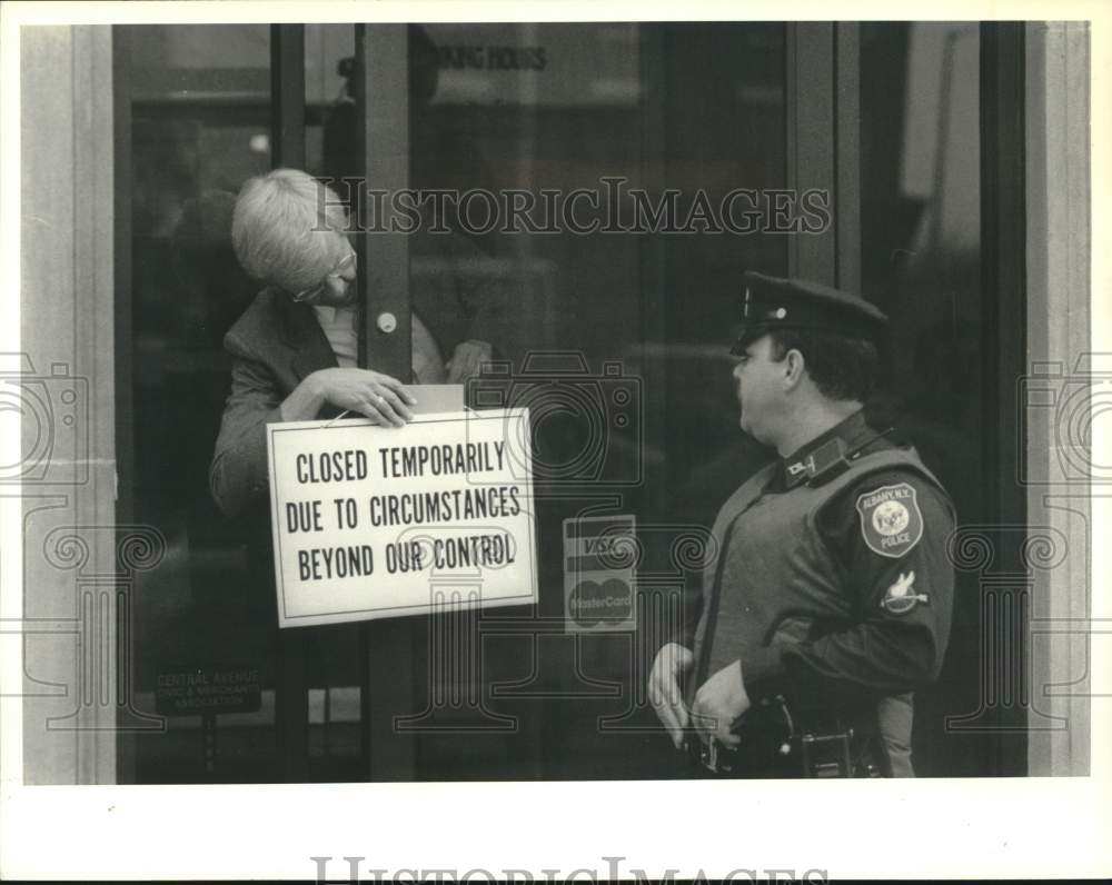 1989 Press Photo Bank employee hangs closed sign after robbery in New York- Historic Images
