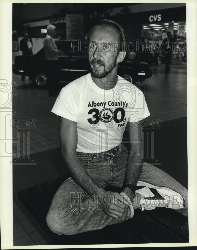 Will Yurman sits iin shopping mall wearing Albany County NY t-shirt - Historic Images