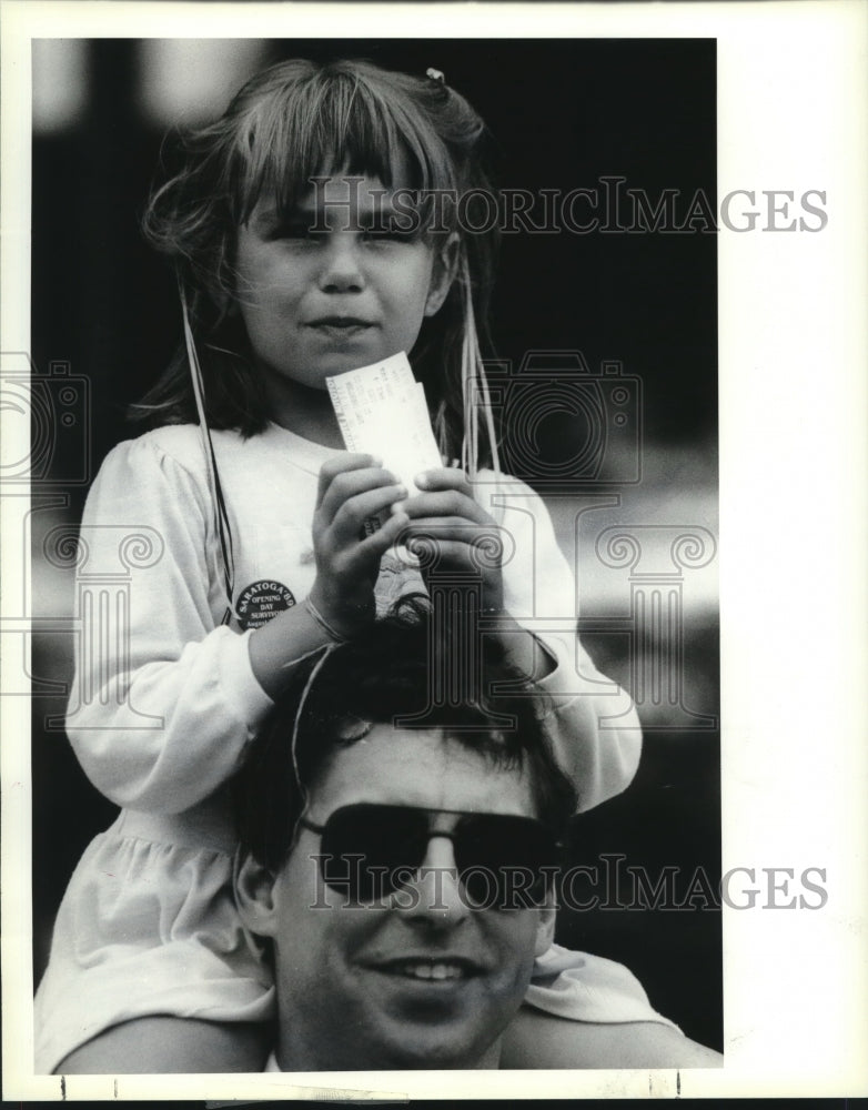 1980 Press Photo Caitlyn Gausfuss, 4, sits on fathers shoulders to watch race - Historic Images