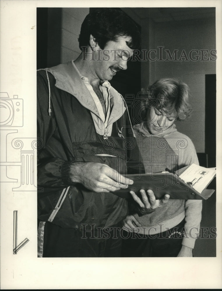 1984 Press Photo College of St Rose coach &amp; student look over book in New York - Historic Images
