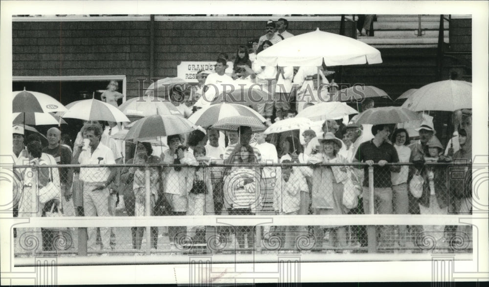 1990 Press Photo Fans watch horse race in the race at Saratoga Raceway, New York- Historic Images