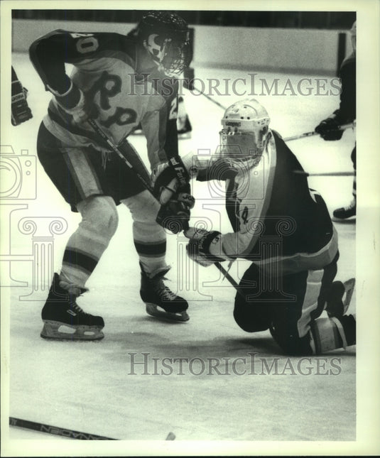 1987 Press Photo Babson player #4 grabs on to RPI's #20 stick after losing his