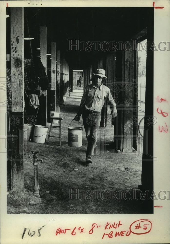 1974 Press Photo Butram Robinson carries bucket at Saratoga Track Stables, NY - Historic Images