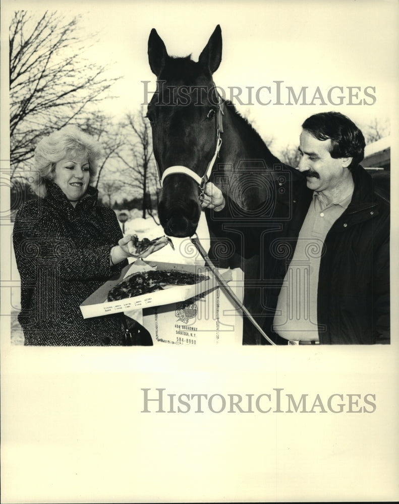 1986 Press Photo Tough Dancer gets slice of pepperoni pizza from owners - Historic Images