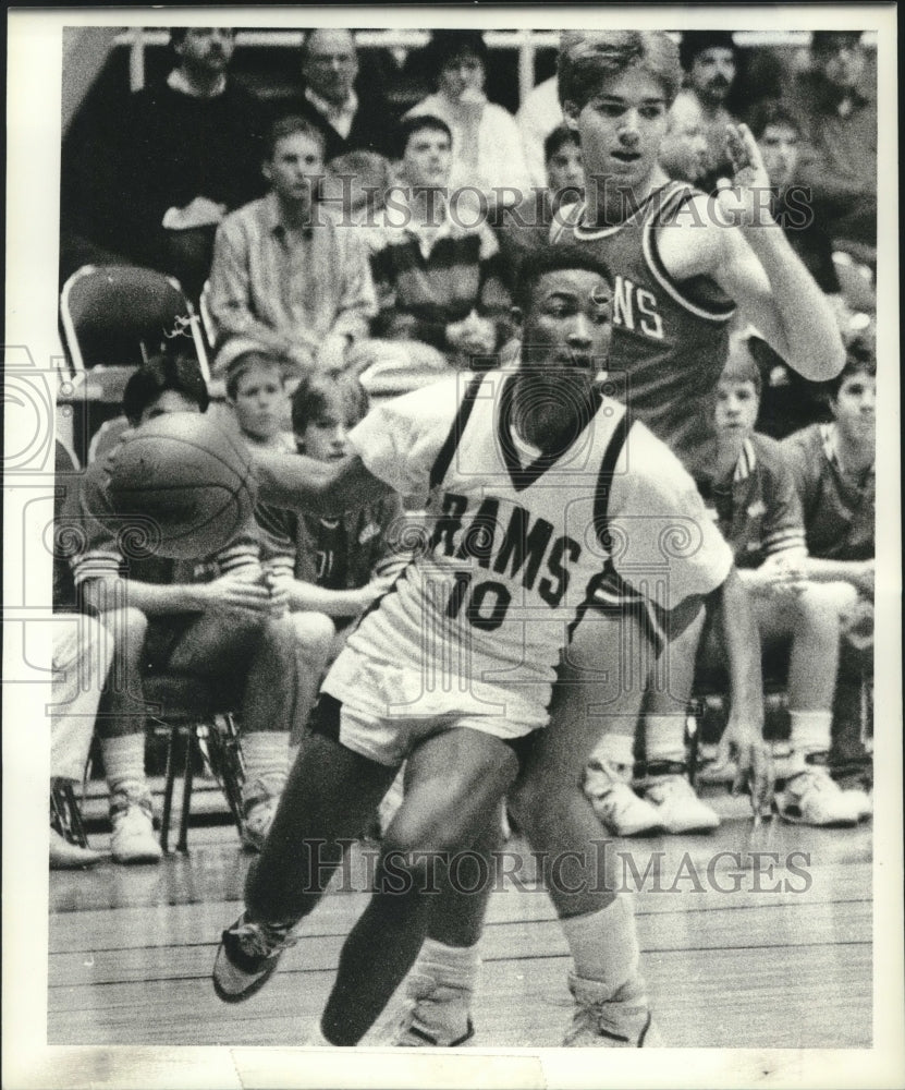 1989 Press Photo Rensselaer Rams basketball player #10 drives around defender - Historic Images