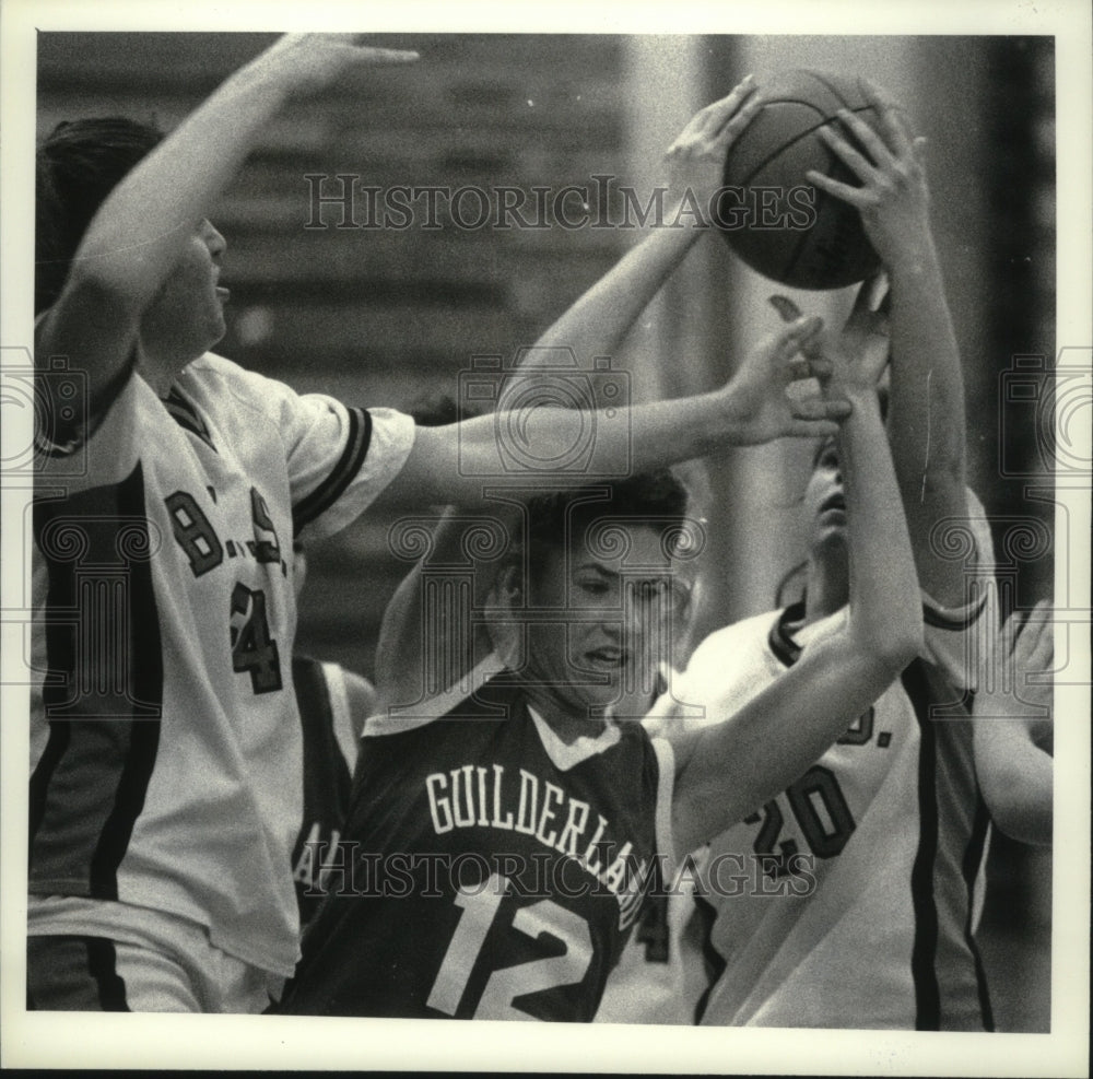 1990 Press Photo Guilderland basketball player #12 is sandwiched by defenders - Historic Images
