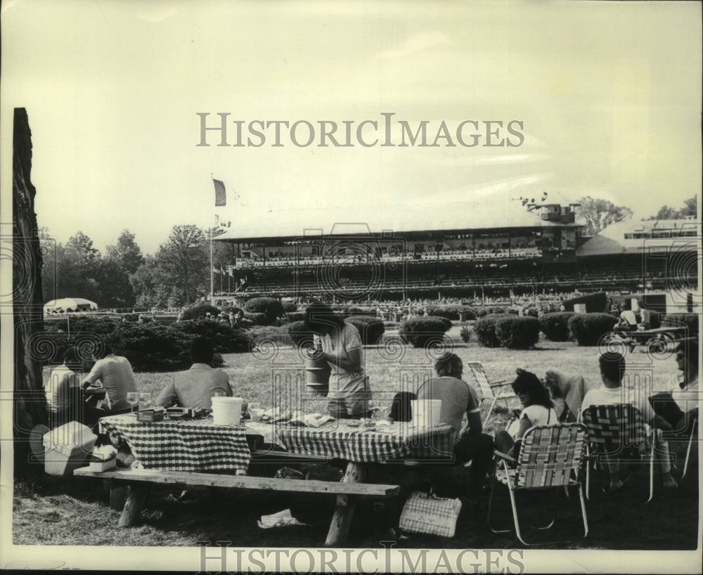 Press Photo Crowd picnics on infield of Saratoga Track, grandstand in background- Historic Images