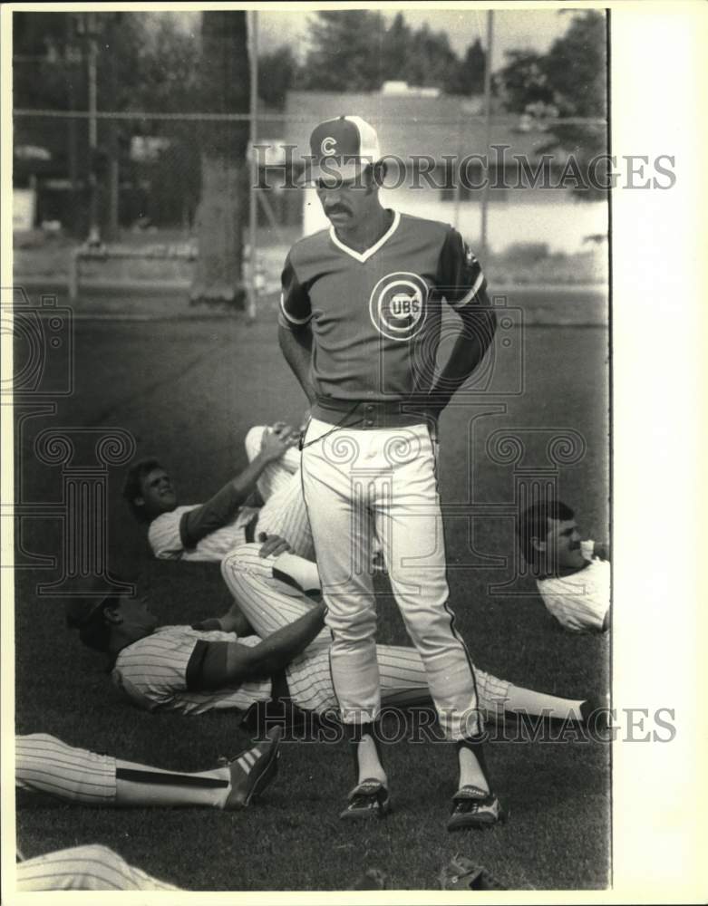 Press Photo A man in a Cubs baseball uniform watches players stretch - tus05964- Historic Images